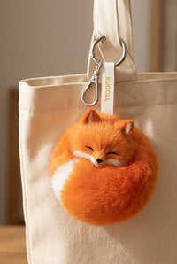 Red and white Kudoll sleeping fox plush keychain, soft fox bag charm with detailed features and adorable design.