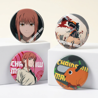 Chainsaw Man Omomori tinplate pin badges from the blind box collection displayed at angled views on white pedestals