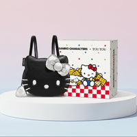 Black cat-shaped backpack with a bow next to a box featuring Sanrio characters on a light blue background