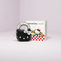 Black cat-shaped keychain with silver ring next to a box featuring cartoon characters on a black background