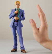 Action figure in a purple suit next to a hand on a neutral background
