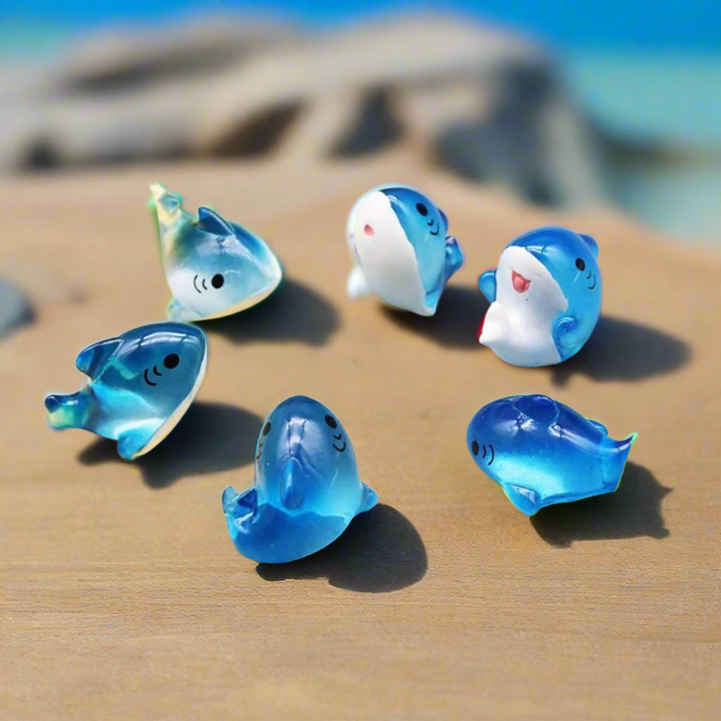 Set of blue dolphin-shaped figurines on a yellow background with 'JIQING HU' branding.