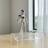 Action figure on a clear stand in a room with a window