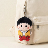 Plush charm displayed on a cream backpack